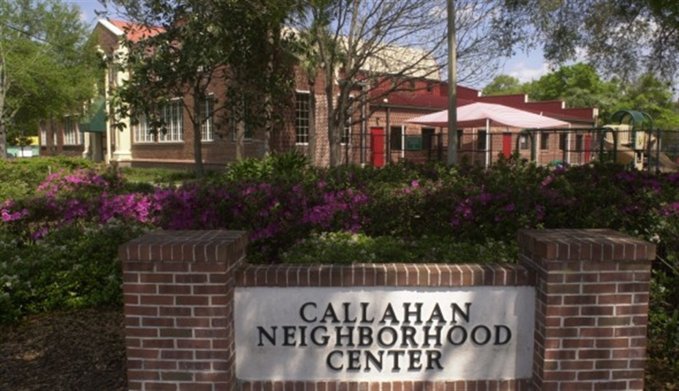 Exterior of Callahan Neighborhood Center: Sturdy brick building with trees, flowers, and prominent sign, creating a welcoming atmosphere.